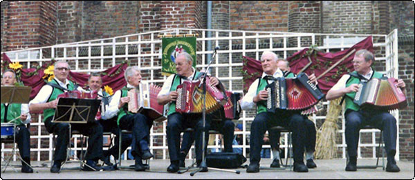 The Monicas from Halle-Heide playing at the Market-place during a BBQ in Ruurlo in augustus 98. Monica is the nickname for the squeezebox in the Achterhoek, a border district in the East of the Netherlands. In this region especially, older men enjoy playing kitchen music, on impressive multiple-row cupboards. But anyhow: the diatonic here is still an authentic instrument for playing folk music.