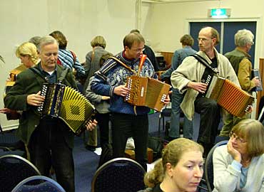 Irina pakte het met de iets minder prille beginners heel anders aan. Zij mochten bij de presentatie nòch naar bladmuziek, nòch naar elkaar kijken en stonden dus met de ruggen naar elkaar. Dat was even wennen en voor sommige cursisten een behoorlijke hindernis. Het is echter te hopen dat Irina deze methode handhaaft: mensen die bij haar intekenen weten nu waar ze aan toe zijn. Leerzaam is het zeker voor mensen, die uit hun hoofd willen spelen en meer op het gehoor willen werken.