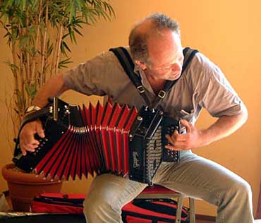 Bert van Baar uit groet, achter zijn trekharmonika, op de service-pagina van de Volkrant van vrijdag17december.