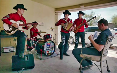 De band speelt de corrido. Tom Waes houdt de tekst voor zijn borst.