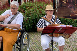 Bij de Drommedaris. Bij dit havengebouw tref je ook veel spelers n publiek.