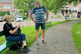 Een nieuwsgierige voorbijganger in gesprek met Anja van der Veen.