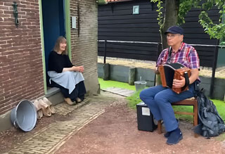 Muziek maken voor de bewoonster van een arbeidshuisje in het Buitenmuseum