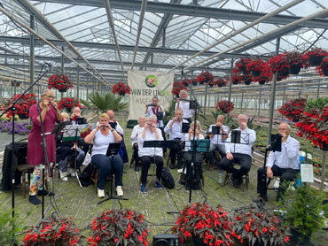 De Helmondse Mondharmonica vereniging oefent in een plantenkas. Zo wordt de CO2-uitstoot direct opgenomen door de planten en wordt de opwarming van de aarde tegen gegaan. 
