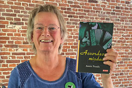 Jeanet toont het boek waarop haar voorstelling De Groene Harmonica is gebaseerd: Accordeon nisdaden van Annie Proulx.