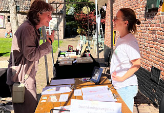 Ook Tineke Lemmens is er. Zij tekent veel mensen met trekzak. Dit keer was ze niet de enige tekenares/schilderes, want er was voor het eerst een kunstmarkt.