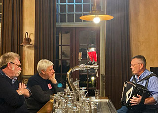 John deed de bar. Hij is behalve barman en organisator een echte gangmaker met een heel uiteenlopend repertoire op zijn drierijer.