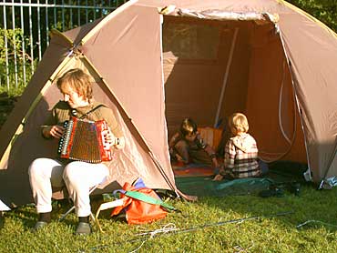 Avondtafereeltje tijdens Trek er es Uut 2004. Moeder aan de trekzak, kinderen aan het Yu-Gi-Ho! kaartspel.