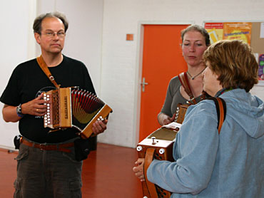 Ook de oudere muzikanten oefenen druk in de gang. Hier drie deelnemers aan de groep van Marinette Bonnert.