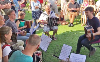 De gemengde groep (het orkest) treedt aan op het bordes.